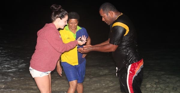 Sarah Bowden hands over a baby turtle to Iosefo Vanavana at South Sea Island.